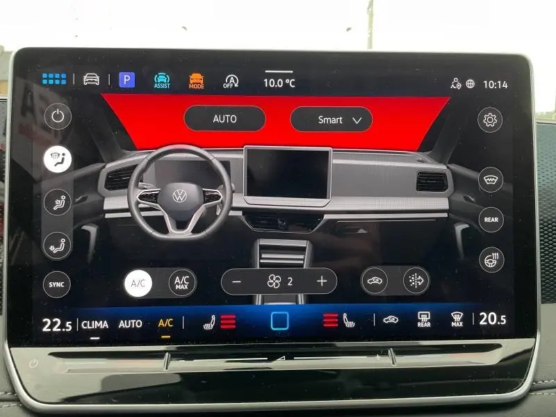 Écran tactile affichant l’interface de climatisation du Volkswagen Tiguan blanc, vue frontale du tableau de bord.