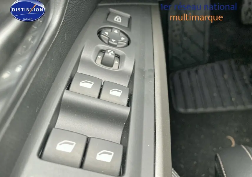 Gros plan sur les commandes des vitres électriques côté conducteur du Peugeot 3008 bleu 2025.