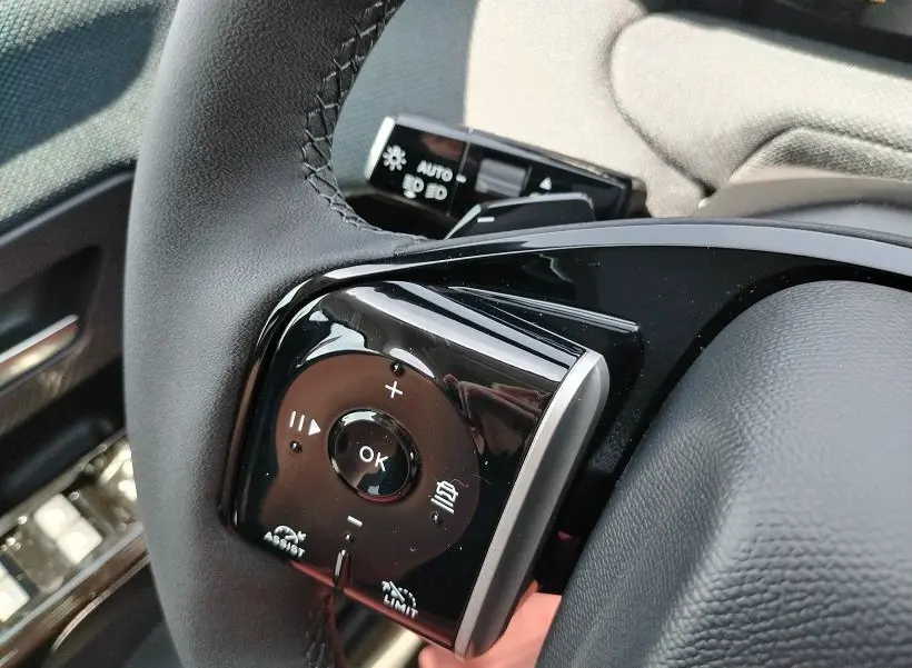 Gros plan sur les commandes au volant noir du Citroën C5 Aircross Hybride 2026, côté gauche, avec boutons multifonctions.