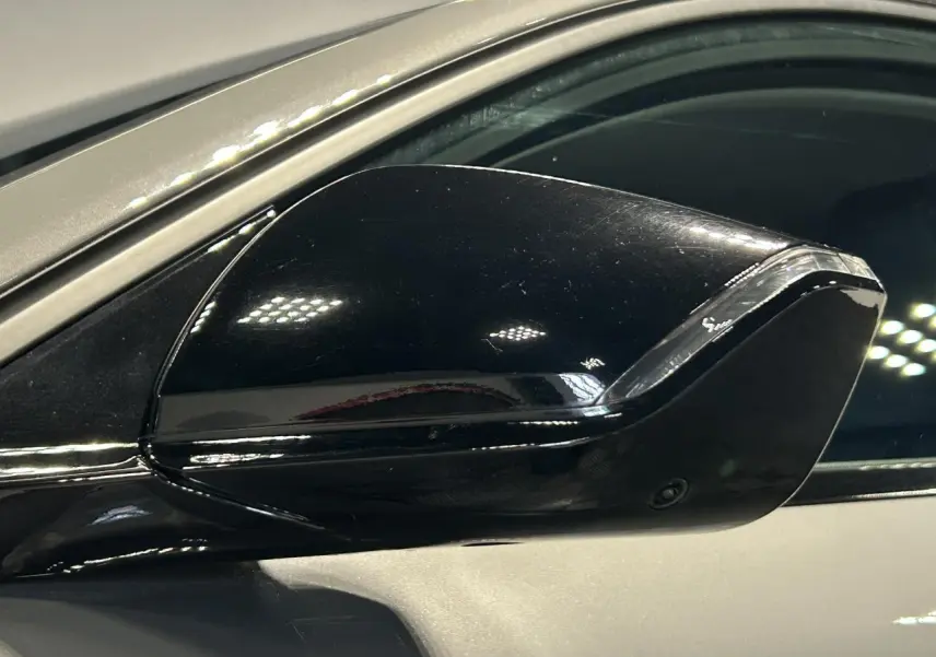 Rétroviseur extérieur noir brillant côté conducteur sur Peugeot 308 SW gris Sélénium, vue rapprochée.