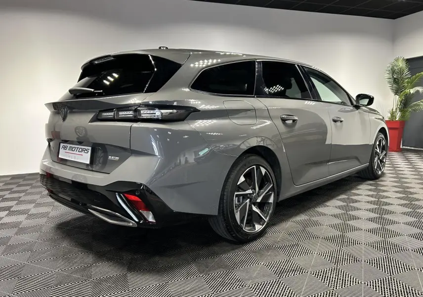 Vue 3/4 arrière droit d'une Peugeot 308 SW gris Sélénium avec jantes alliage 17'' et feux LED distinctifs.