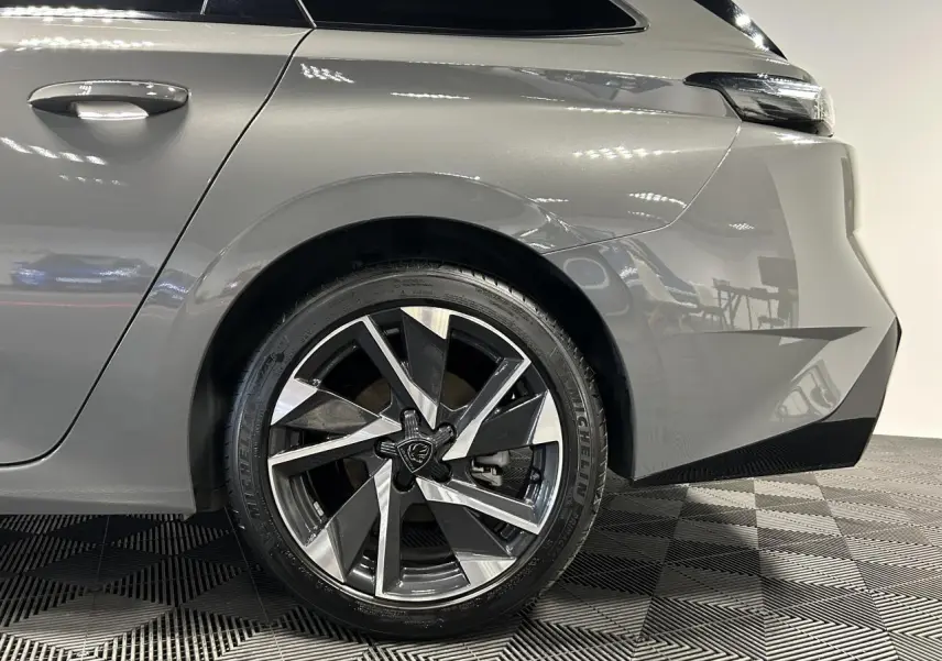 Gros plan sur la roue arrière droite et la carrosserie gris Sélénium d'une Peugeot 308 SW 2025 avec jante alliage 17'' Halong.