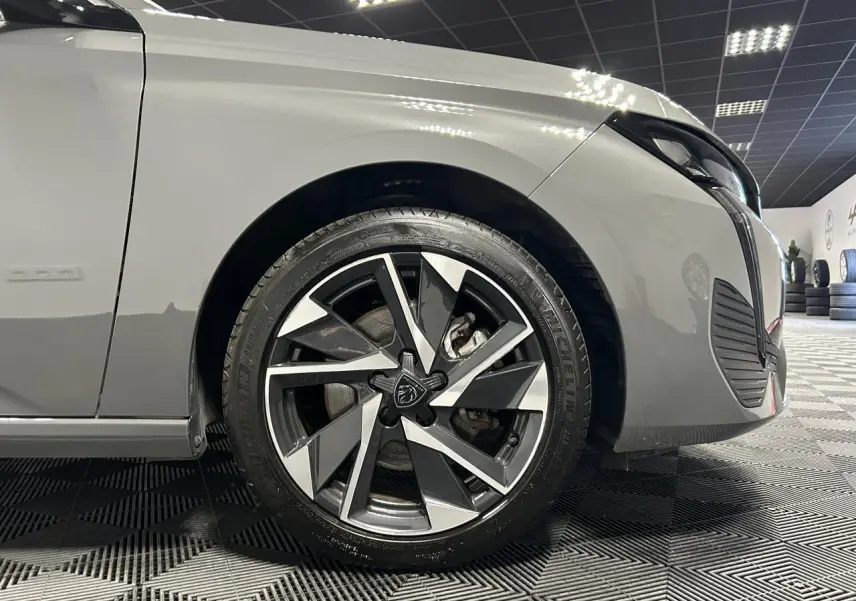 Gros plan sur la roue avant droite de la Peugeot 308 SW gris Sélénium avec jante alliage 17'' Halong diamantée.