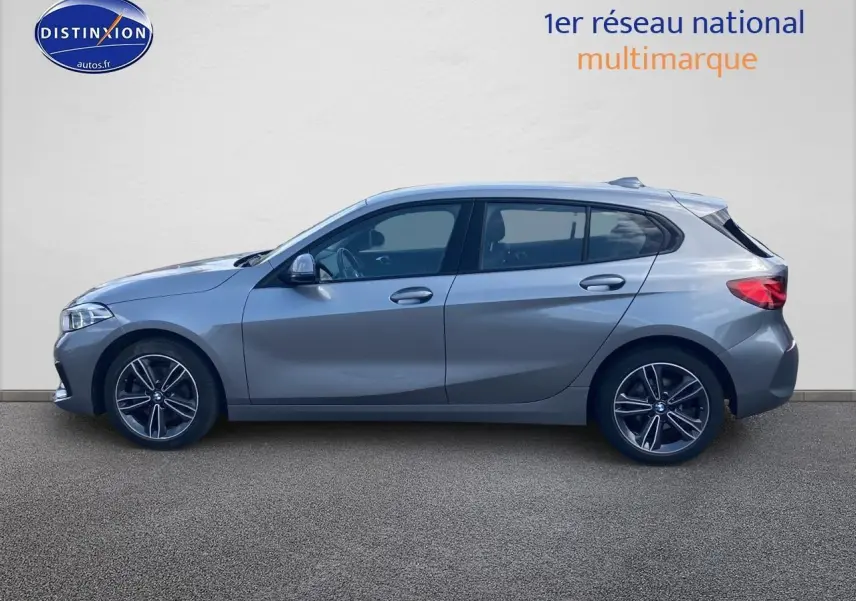 Profil côté gauche d'une BMW Série 1 gris foncé 2023 avec jantes alliage et lignes sportives marquées