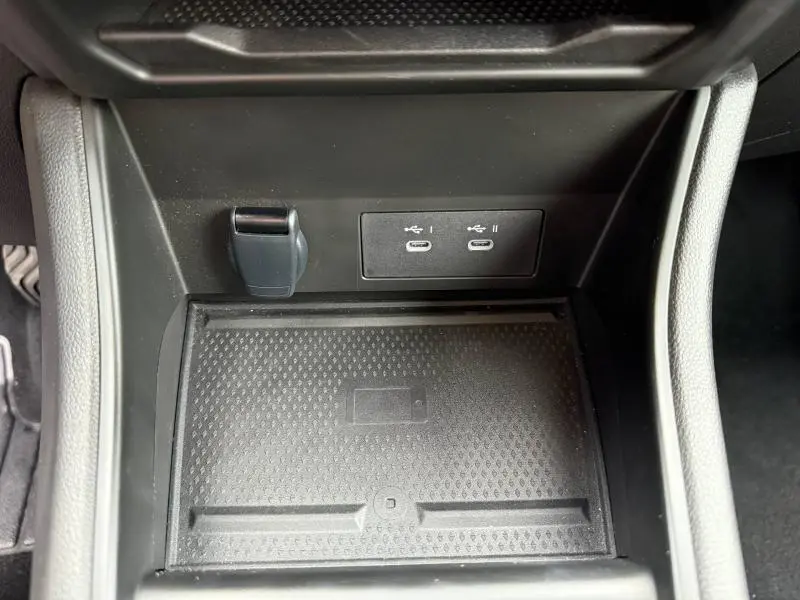 Gros plan intérieur sur la console centrale du Renault Captur 2025, montrant les ports USB-C et un espace de recharge sans fil.
