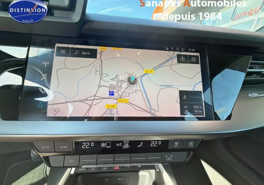 Vue rapprochée de l’écran central tactile et de la console de la Audi A3 Sportback blanche, affichant la navigation.