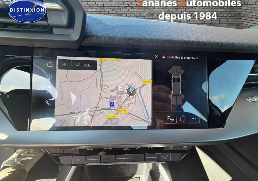 Vue intérieure du tableau de bord de l'Audi A3 Sportback 2023 avec écran de navigation et affichage du parking assisté.