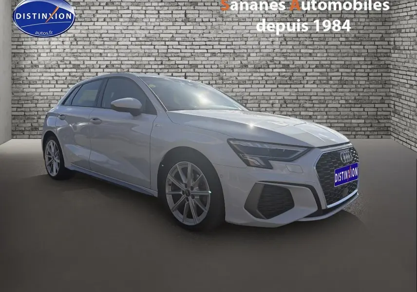 Audi A3 Sportback blanc vue 3/4 avant droit avec jantes alliage et calandre S line devant un mur en briques.