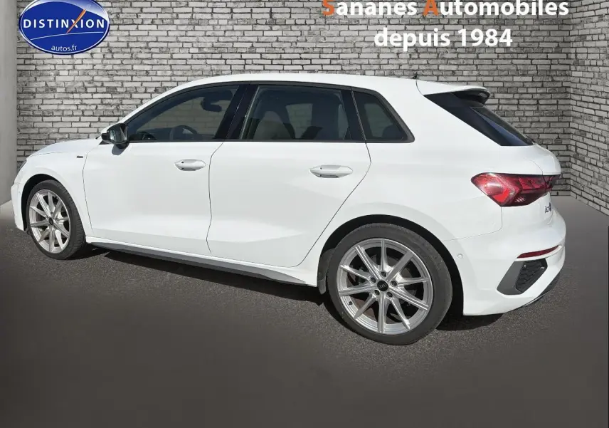 Audi A3 Sportback blanc vue de profil côté gauche, avec jantes alliage et lignes épurées visibles.