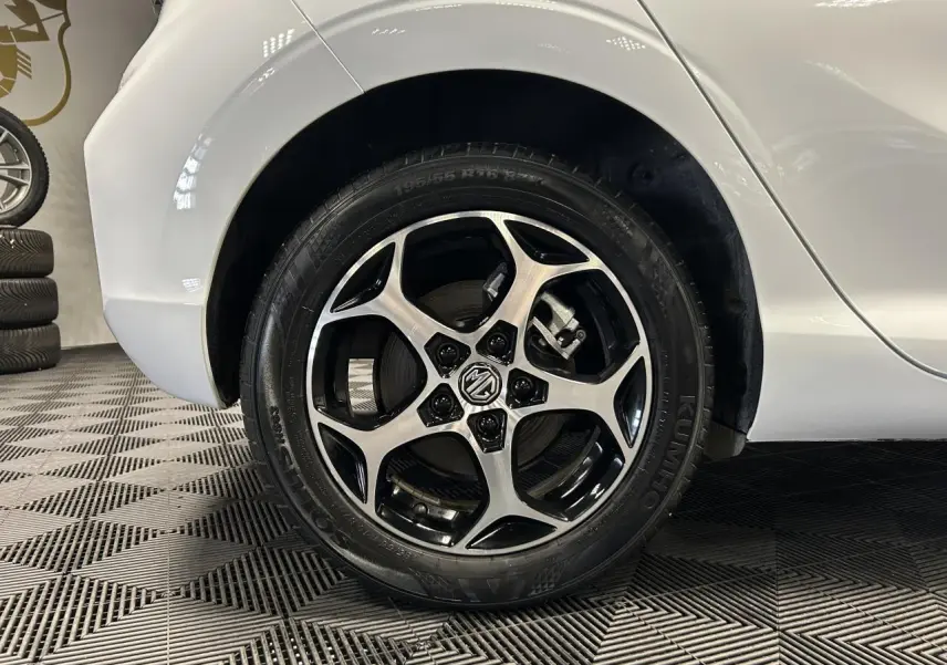 Gros plan sur la roue arrière droite blanche d'une MG3 1.5 Hybrid+ 195ch Comfort avec jante alliage noire et argentée.