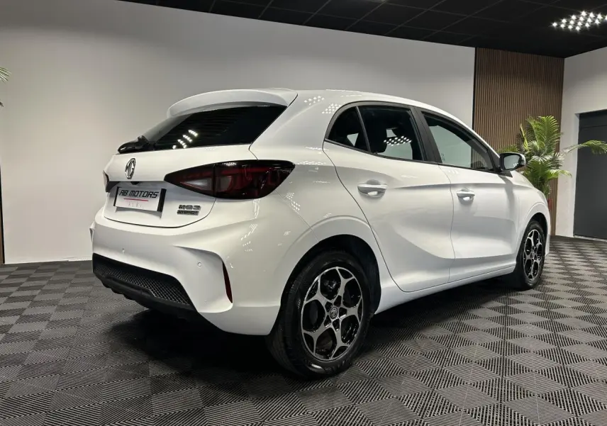 Vue 3/4 arrière droite d'une MG3 1.5 Hybrid+ blanche avec jantes alliage noires et feux arrière fumés.