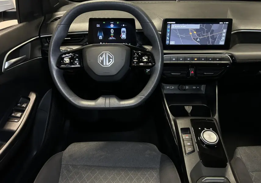 Vue intérieure avant centrée sur le volant et tableau de bord noir du MG3 1.5 Hybrid+ 2025 avec écran tactile et compteur digital.