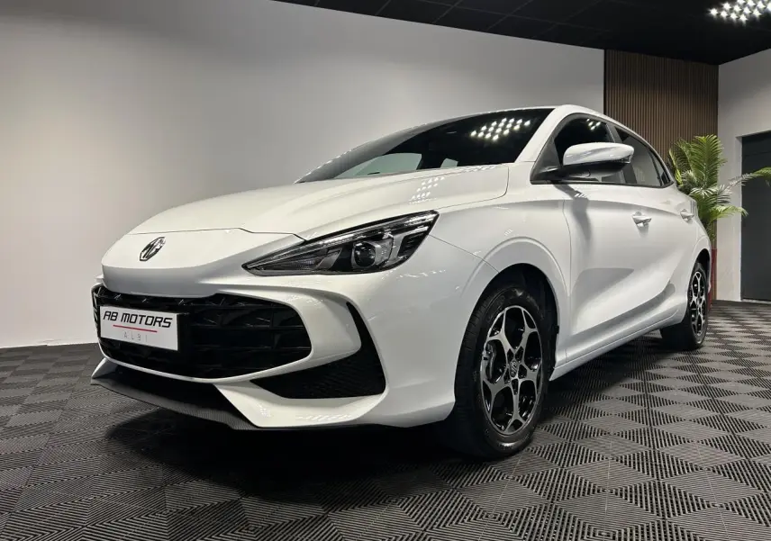 Vue 3/4 avant droite de la MG3 blanche 2025 avec jantes alliage noires et calandre large noire brillante.