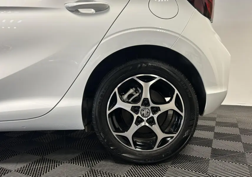 Gros plan sur la roue arrière droite en alliage noir et argent d’une MG3 blanche 2025.