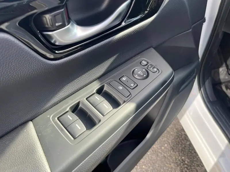 Gros plan sur la commande des vitres et rétroviseurs côté conducteur du Honda CR-V 2024 blanc métallisé.