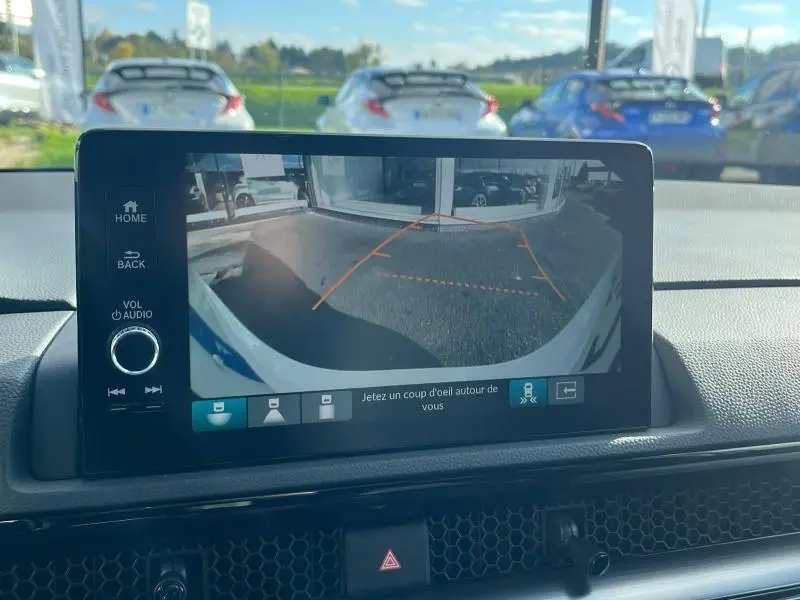 Vue de l'écran tactile du Honda CR-V 2024 montrant la caméra de recul avec lignes de guidage orange.