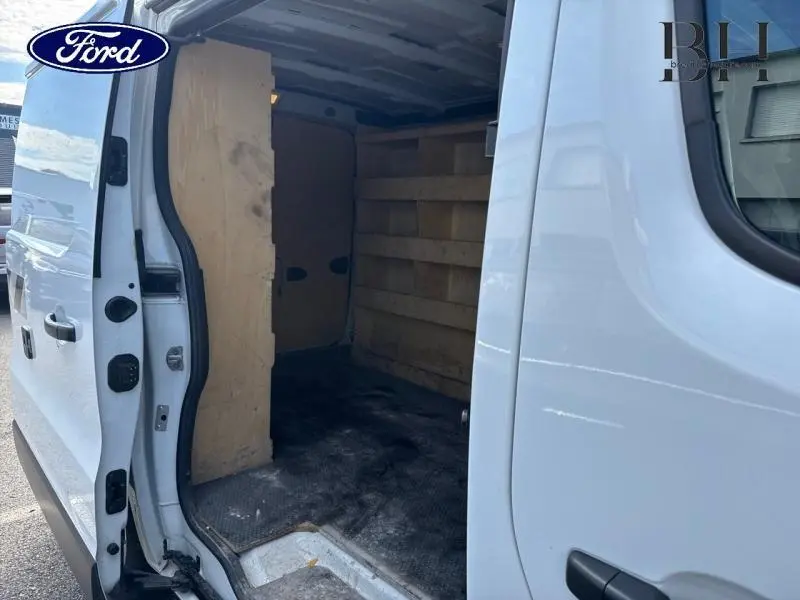 Vue latérale gauche d'un Renault Trafic Fourgon blanc glacier avec porte coulissante ouverte révélant l'intérieur habillé en bois.