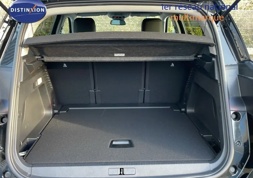 Coffre ouvert vu de l'arrière d'un Citroën C5 Aircross noir perla metal, montrant l'espace de chargement et la tablette cache-bagages.
