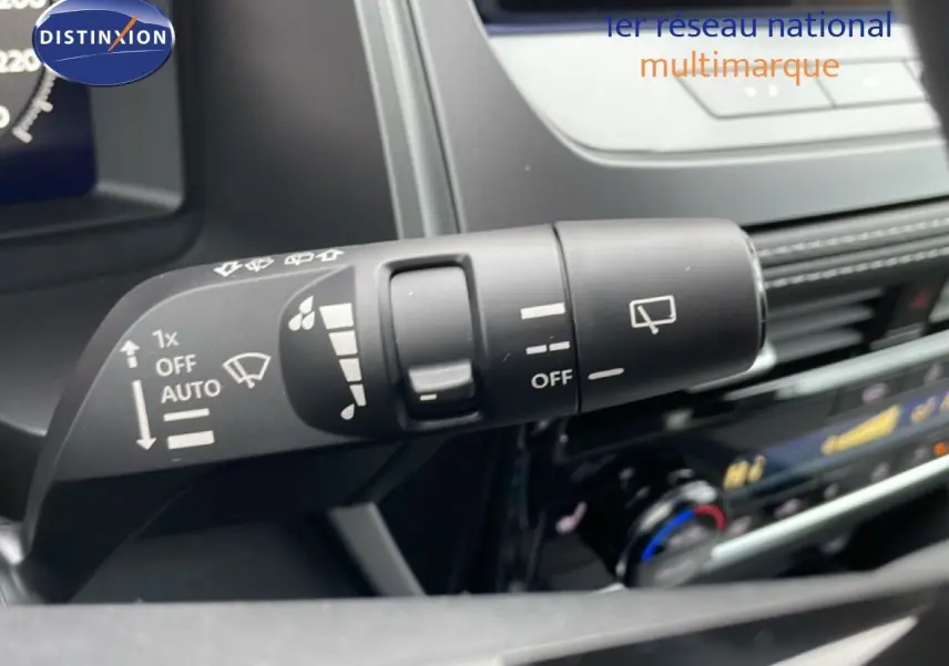 Gros plan sur la commande d’essuie-glace à gauche du volant dans l’habitacle du Nissan Qashqai blanc nacré 2025.