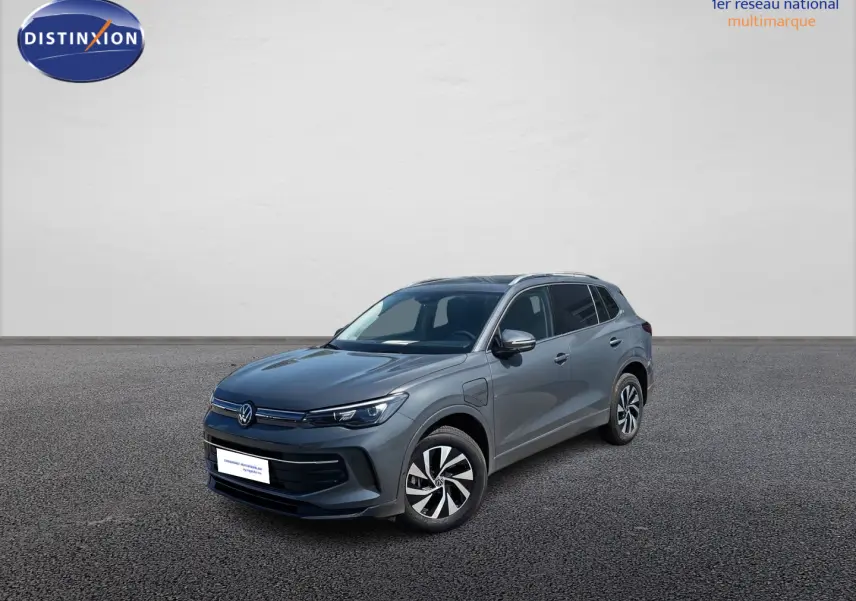Volkswagen Tiguan 1.5 eHybrid gris vu en 3/4 avant droit avec jantes alliage et calandre épurée.