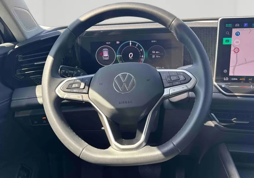 Vue rapprochée du volant multifonction noir et du tableau de bord numérique du Volkswagen Tiguan eHybrid 2025.