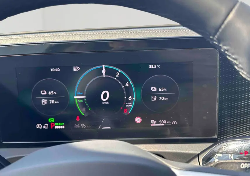 Vue rapprochée du tableau de bord numérique du Volkswagen Tiguan gris, affichant les indicateurs de vitesse et batterie.