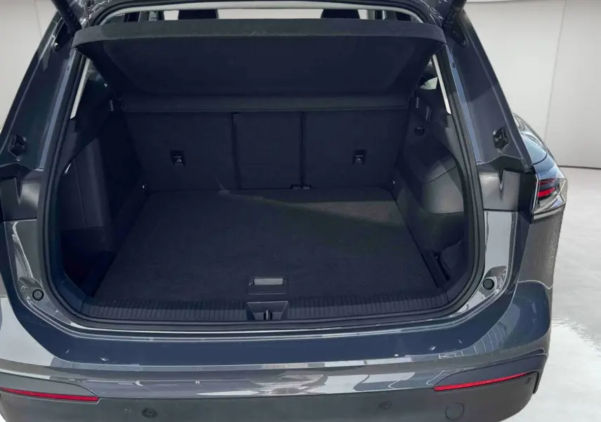 Coffre ouvert vu de l'arrière d'un Volkswagen Tiguan 2025 gris, avec feux arrière LED 3D visibles.