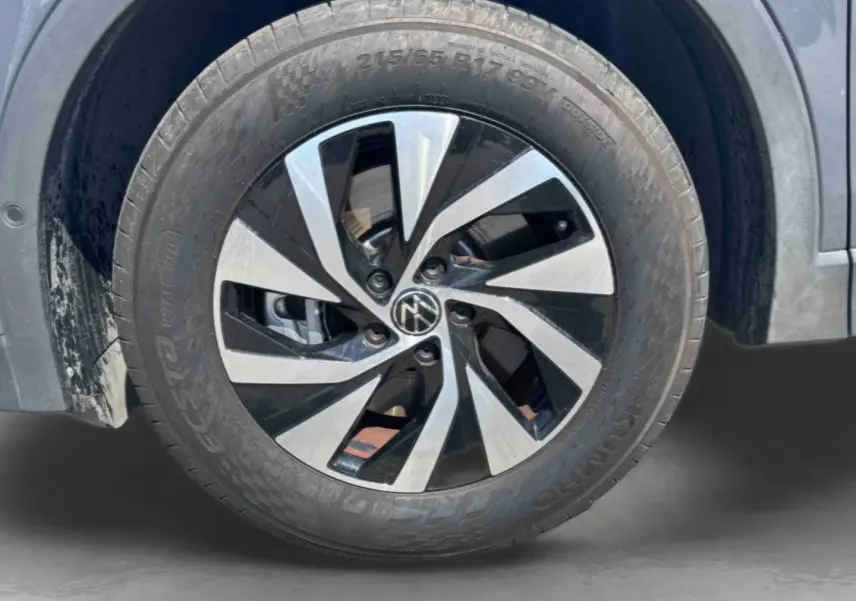 Gros plan sur la roue avant gauche grise du Volkswagen Tiguan 2025 avec jante alliage Venezia 17 pouces bicolore.