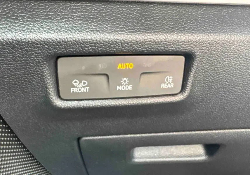 Détail du tableau de bord noir du Volkswagen Tiguan 2025 montrant les commandes d’éclairage automatiques.
