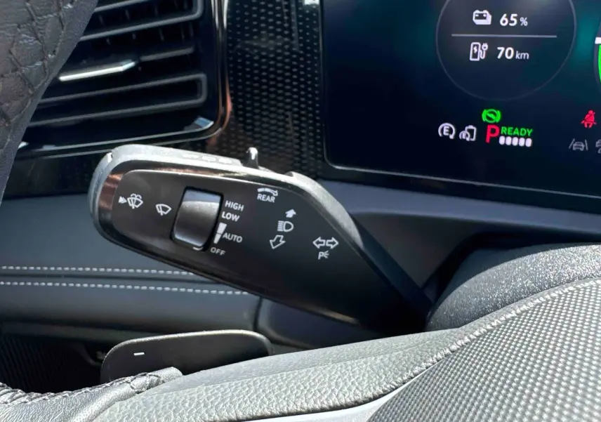Gros plan sur la manette de commandes du volant dans l’habitacle gris du Volkswagen Tiguan eHybrid 2025.