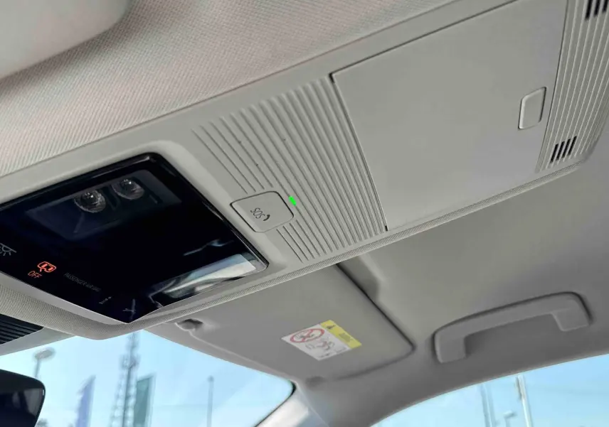 Plafonnier intérieur avec commandes SOS et éclairage, vue du toit clair du Volkswagen Tiguan gris 2025.