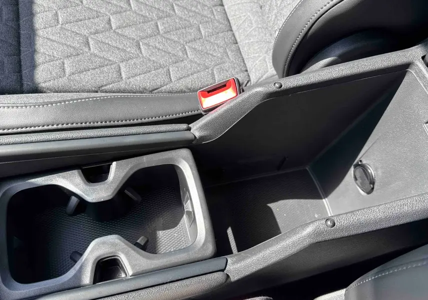 Gros plan sur la console centrale noire avec porte-gobelets et rangement du Volkswagen Tiguan gris 2025.