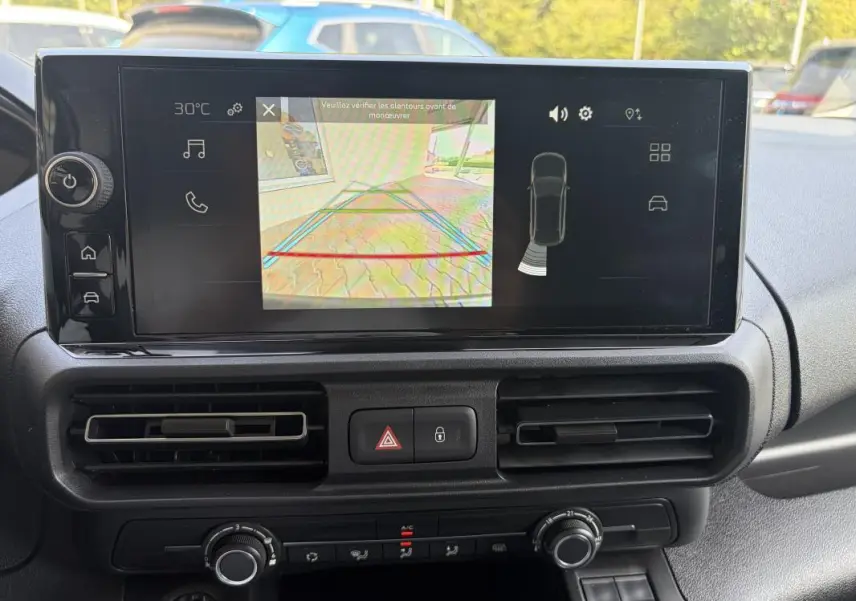 Écran tactile central du Peugeot Partner 2026 montrant la caméra de recul, avec les aérateurs et commandes de climatisation visibles.