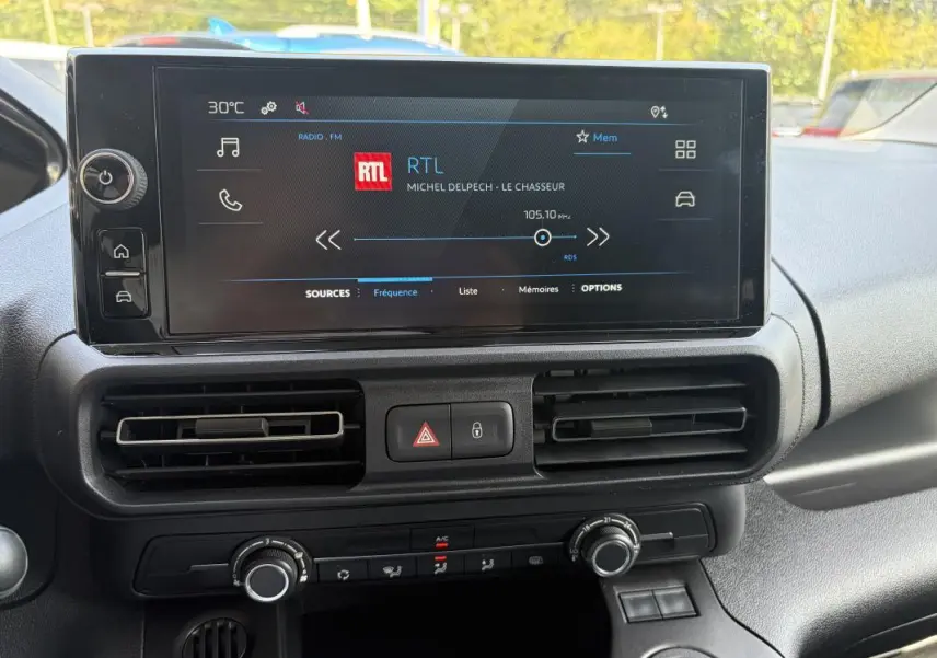 Écran tactile central du Peugeot Partner 2026 affichant la radio RTL, avec commandes de climatisation et ventilation visibles.