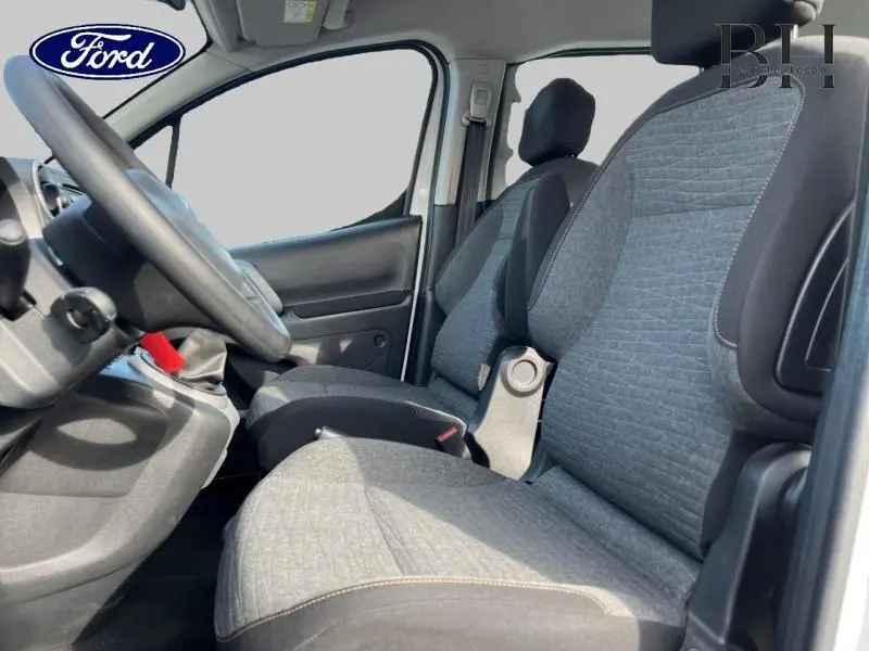 Vue intérieure côté conducteur du Citroën Berlingo 2017, sièges tissu gris et volant noir visible.