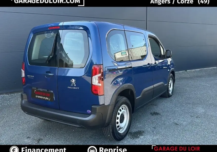 Vue 3/4 arrière droite d'un Peugeot Rifter bleu 2024 avec portes latérales vitrées et jantes acier simples.