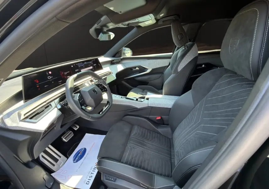 Vue intérieure côté conducteur du Peugeot 5008 2025, sellerie Alcantara noire avec tableau de bord numérique large.