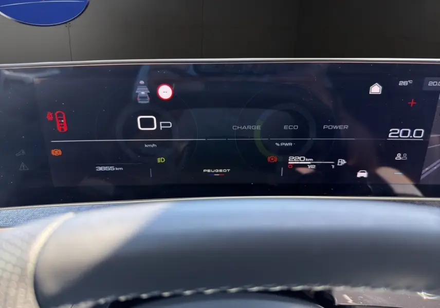 Tableau de bord numérique du Peugeot 5008 hybride 2025 affichant vitesse, autonomie et indicateurs, vue frontale rapprochée.