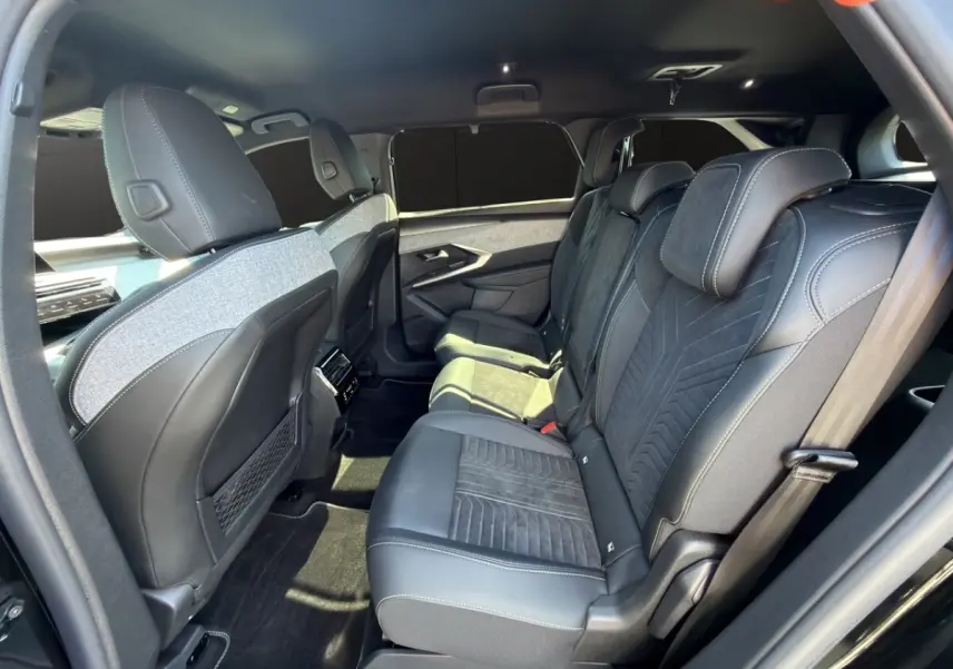 Vue latérale intérieure côté droit montrant les sièges arrière en cuir et alcantara du Peugeot 5008 noir 2025.