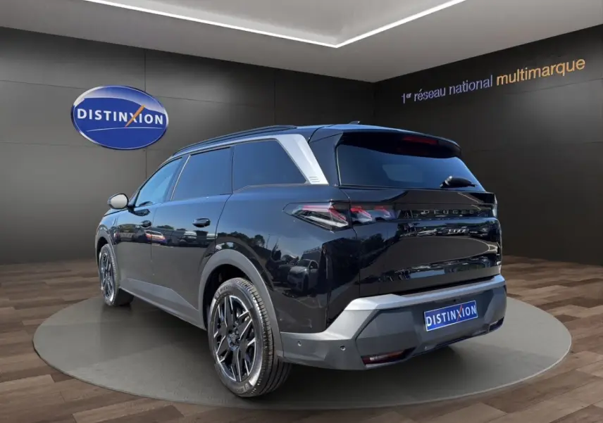 Peugeot 5008 noir en 3/4 arrière droit, avec jantes noires et détails argentés sur le toit et le bouclier.