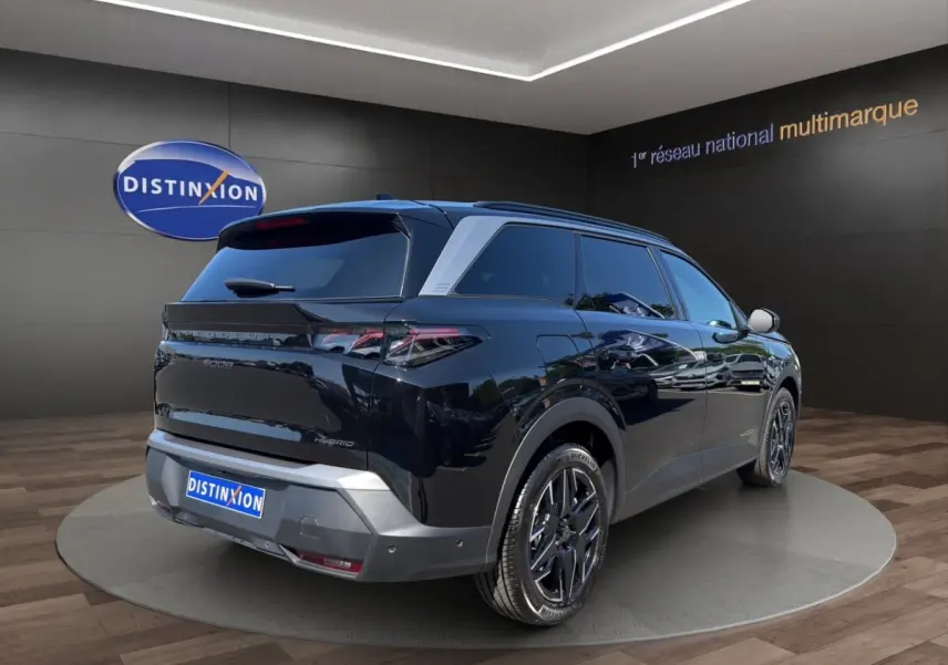 Peugeot 5008 noir vue 3/4 arrière droit, avec jantes alliage noires et vitres teintées en showroom.