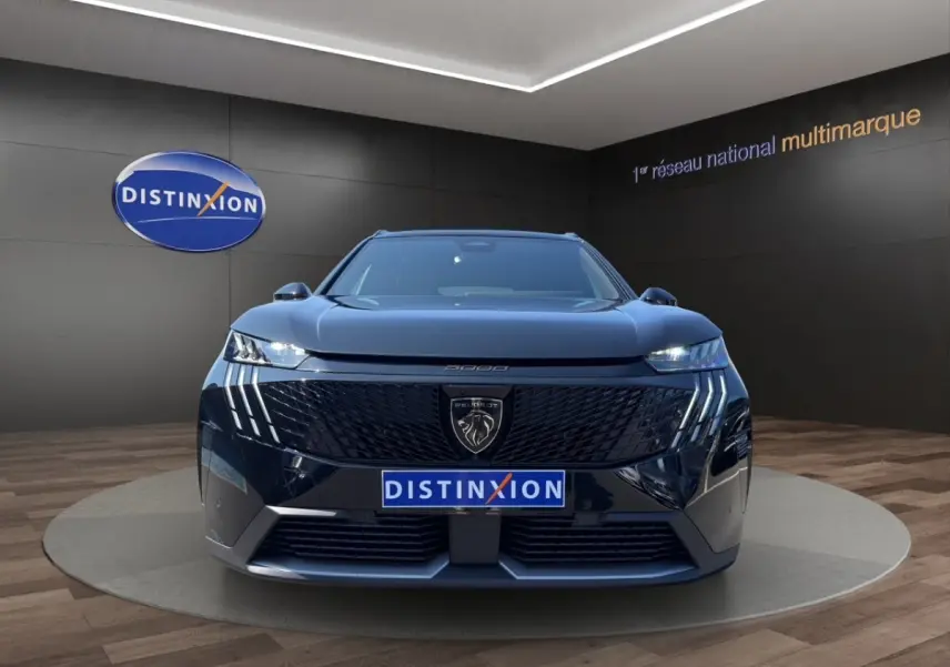 Vue frontale d’un Peugeot 5008 noir avec calandre distinctive et feux LED en forme de griffes.