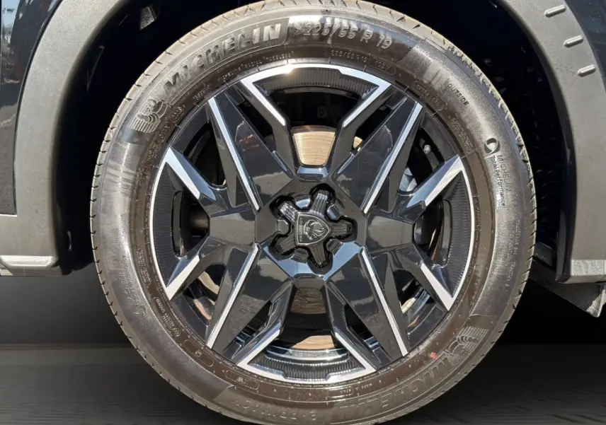 Gros plan sur la roue avant droite noire avec jante Peugeot 5008 1.2 Hybrid 145 GT 2025.