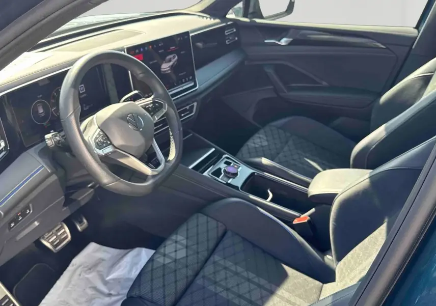 Vue intérieure côté conducteur du Volkswagen Tiguan 2025 avec sièges sport en cuir et tableau de bord numérique.