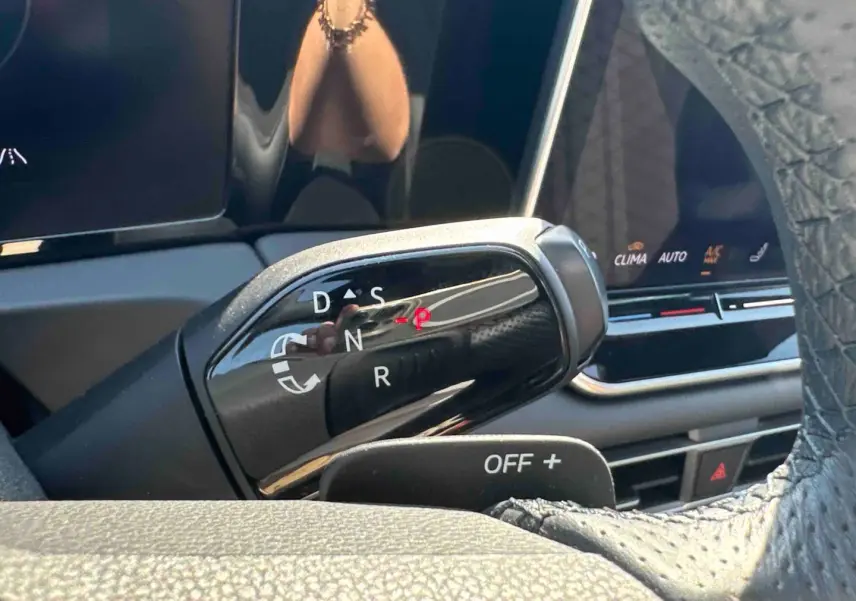 Levier de boîte manuelle noir vu de près dans l'habitacle du Volkswagen Tiguan 2025, avec affichage digital en arrière-plan.