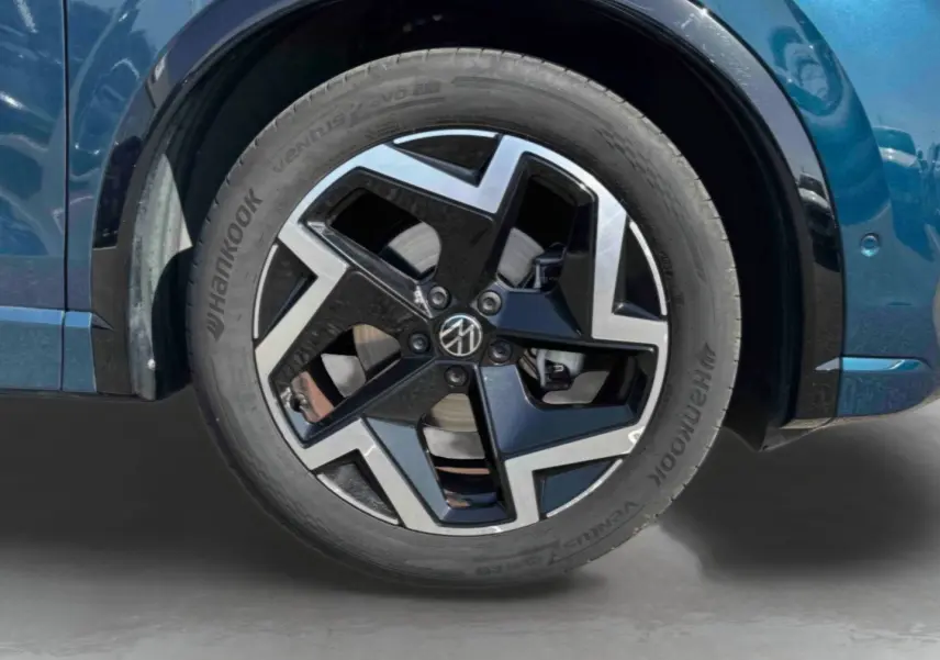 Gros plan sur la roue avant droite du Volkswagen Tiguan bleu 2025 avec jante alliage 19 pouces Coventry.