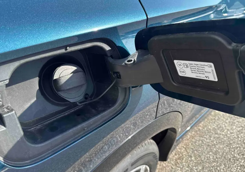 Gros plan sur la trappe à carburant ouverte côté gauche d’un Volkswagen Tiguan bleu 2025.