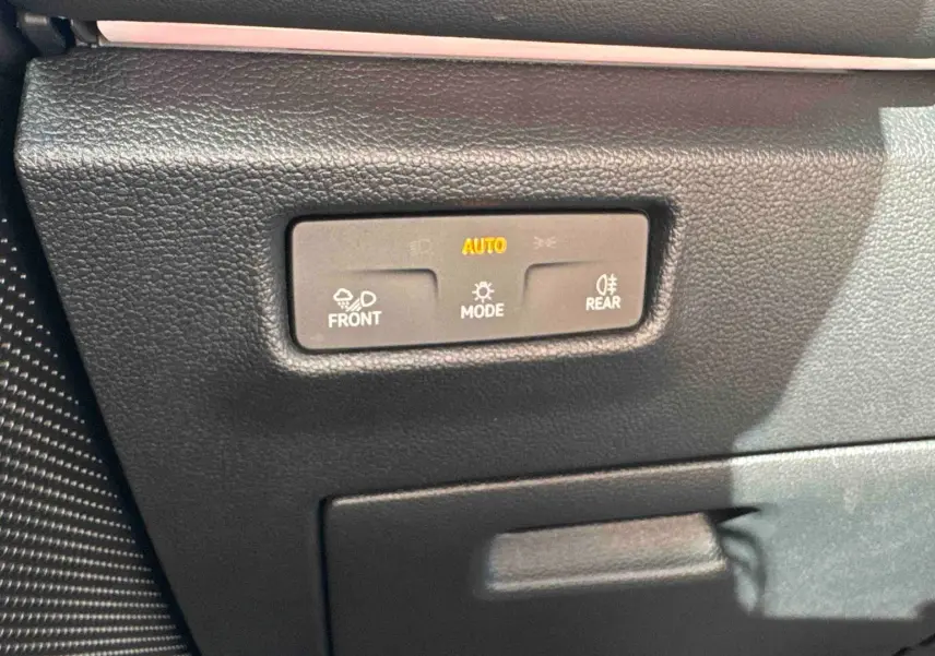 Gros plan sur les commandes d’éclairage automatiques du Volkswagen Tiguan 2025, finition R-Line, intérieur noir.