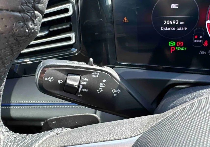 Gros plan sur la manette de commandes des essuie-glaces et clignotants dans l’habitacle du Volkswagen Tiguan 2025 bleu.