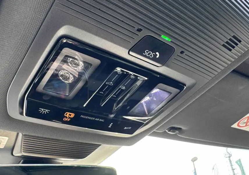 Vue intérieure en gros plan du plafonnier avec commandes d’éclairage et bouton SOS du Volkswagen Tiguan bleu 2025.